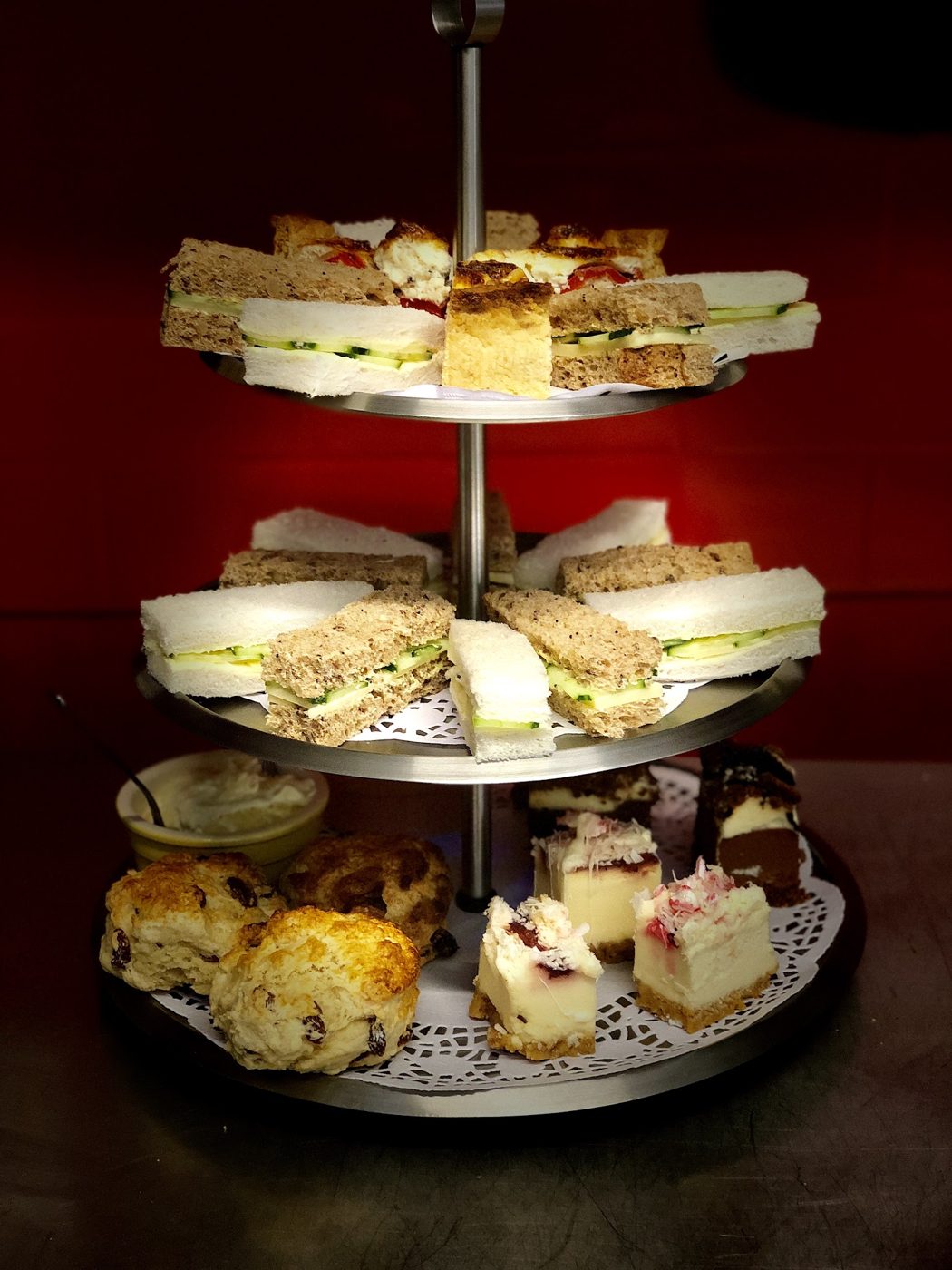 A three-tier stand of sandwiches, scones and cakes