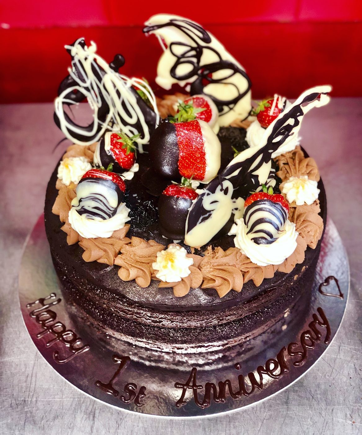 A chocolate celebration cake with dipped strawberries